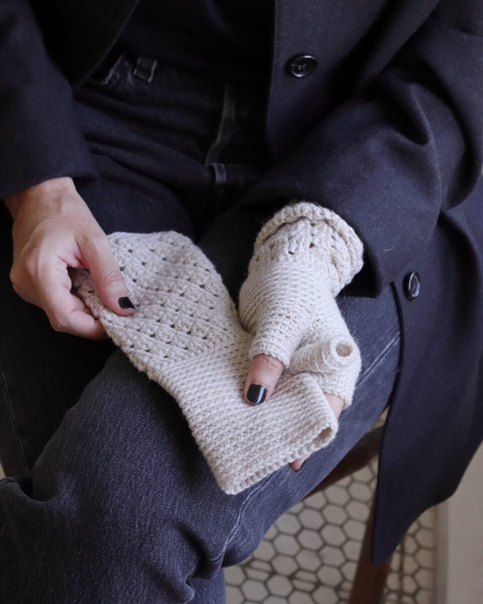 Mitones AVA sostenidos en las manos: parte lisa, pulgar y calado del antebrazo